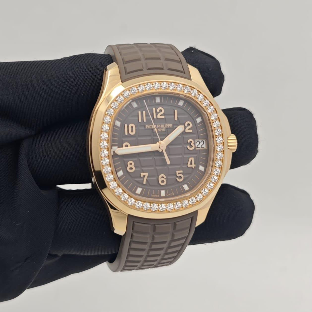 A Perpetual Gold watch with a rose gold case, diamond-accented bezel, and a dark brown textured dial and strap, held by a black gloved hand against a light gray background.